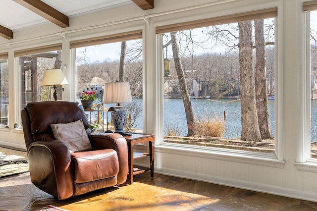 sitting room featuring beam ceiling, a water view, baseboards, and wood finished floors