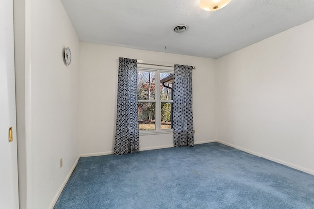 unfurnished room featuring a textured ceiling, carpet, visible vents, and baseboards