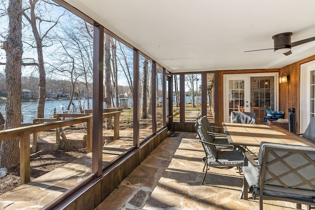 sunroom featuring a water view and ceiling fan