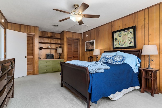 bedroom with light colored carpet, ceiling fan, crown molding, a textured ceiling, and wood walls