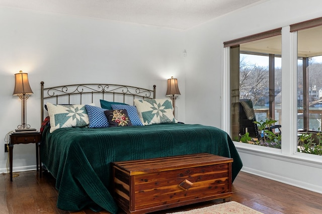 bedroom featuring crown molding, a textured ceiling, baseboards, and wood finished floors