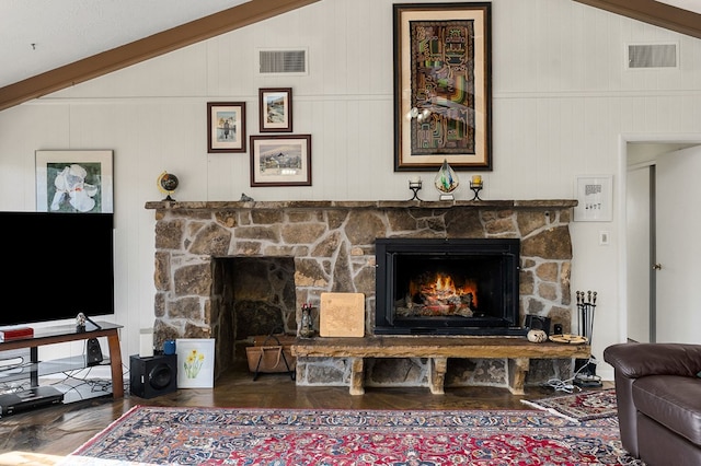 living area featuring vaulted ceiling, a fireplace, wood finished floors, and visible vents