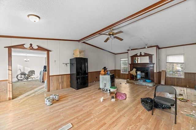 living area with a wainscoted wall, wood walls, and a textured ceiling