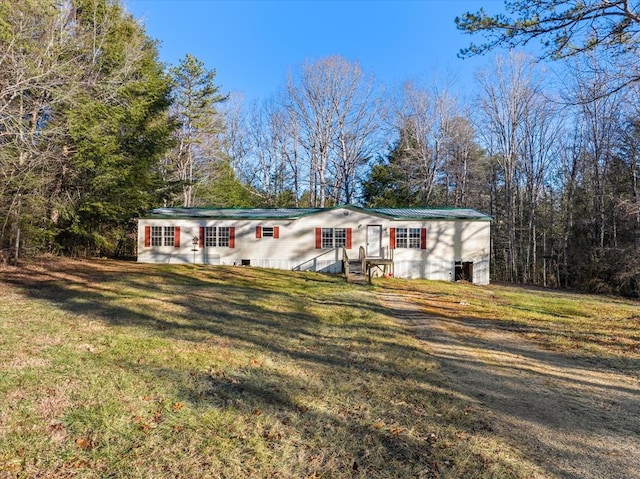 view of front of home featuring metal roof and a front yard