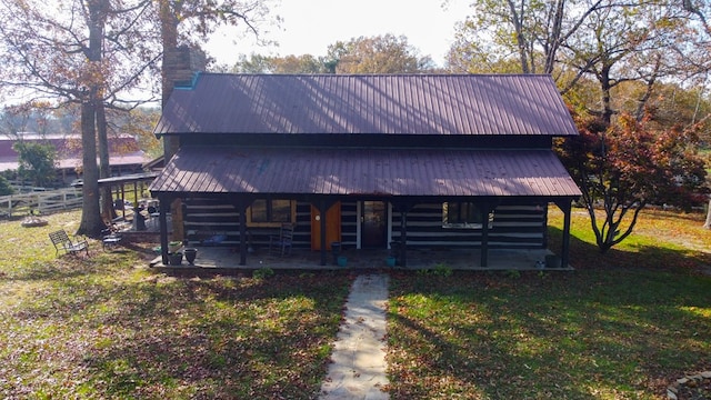 log home with metal roof and a front lawn