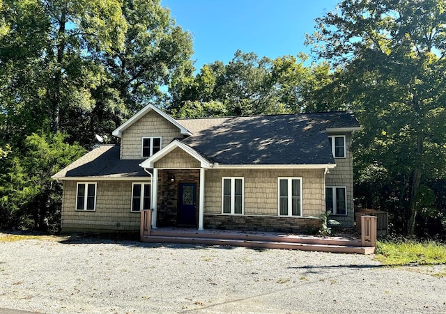 view of front of home featuring a shingled roof and stone siding