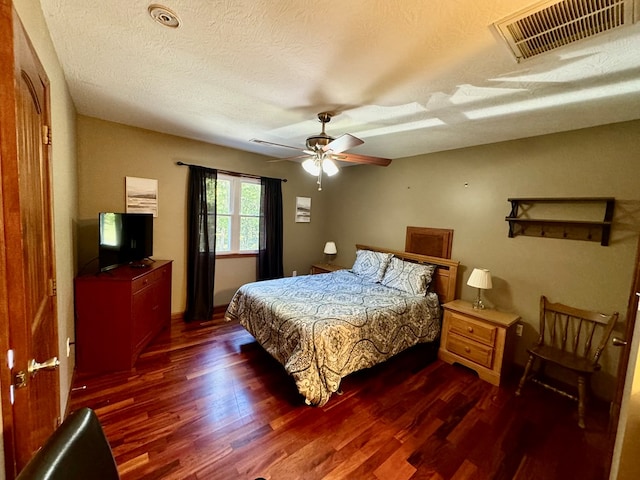 bedroom featuring a textured ceiling, visible vents, and dark wood-type flooring