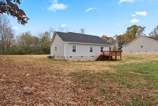 back of property with a deck, stairway, crawl space, and a lawn