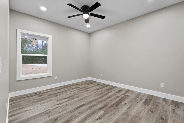 empty room with baseboards, ceiling fan, recessed lighting, and light wood-style floors