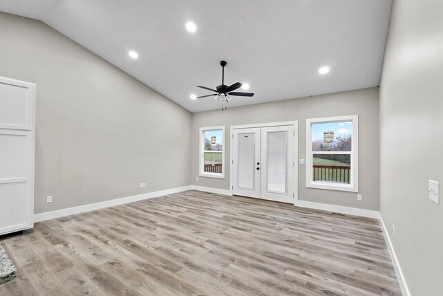 foyer entrance with light wood-type flooring, vaulted ceiling, and baseboards