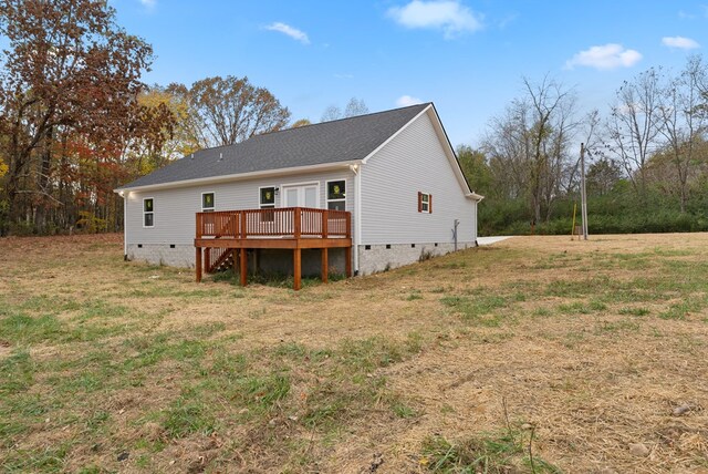 rear view of property with crawl space, a yard, and a wooden deck