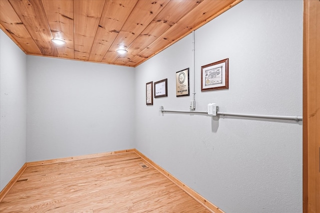 unfurnished room featuring wood ceiling, baseboards, and wood finished floors