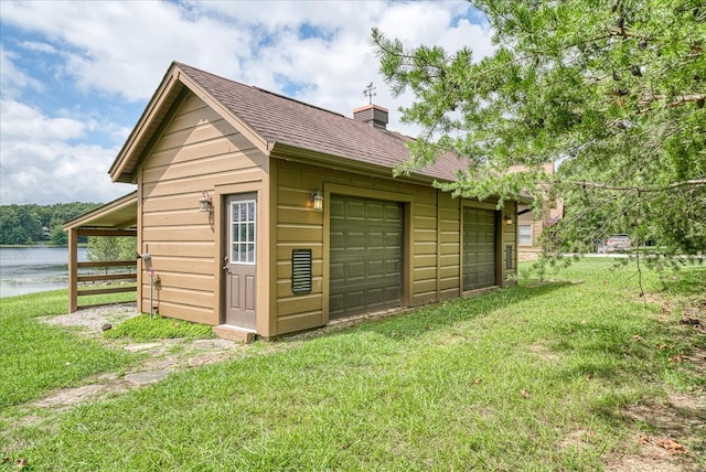 view of outdoor structure with a garage, a water view, and an outdoor structure