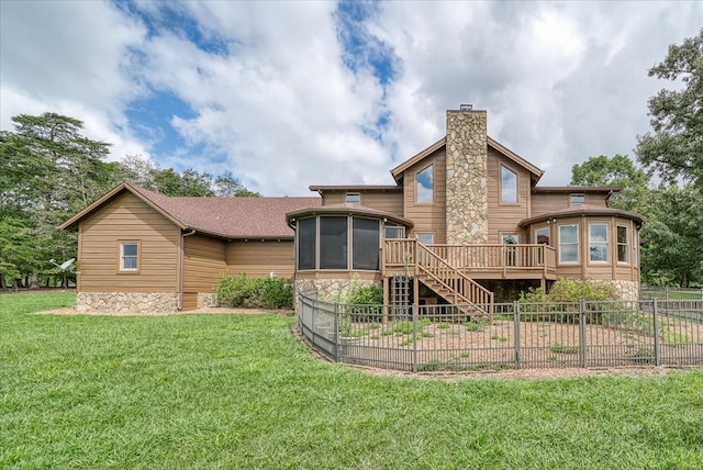 rear view of property with a deck, a sunroom, a lawn, stairway, and a chimney