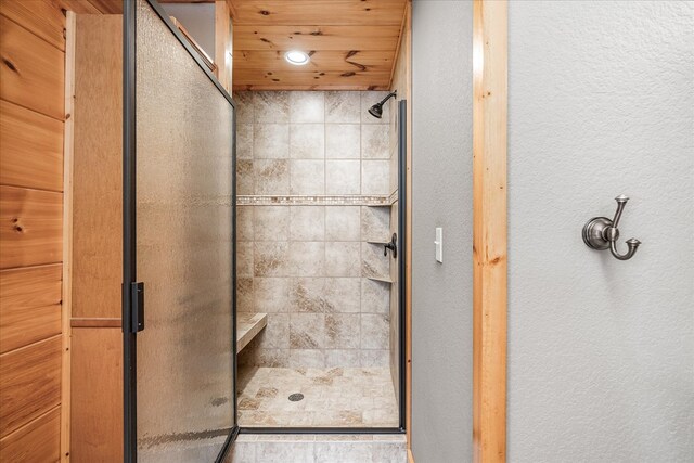 bathroom with a stall shower and wood ceiling