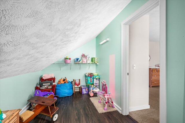 game room with a textured ceiling, vaulted ceiling, wood finished floors, and baseboards