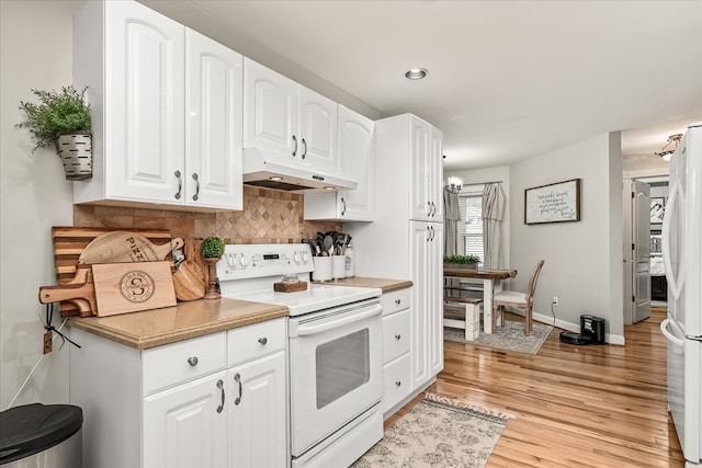 kitchen featuring light wood finished floors, tasteful backsplash, white cabinetry, white appliances, and under cabinet range hood