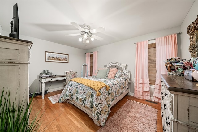 bedroom with light wood-style floors, baseboards, and a ceiling fan