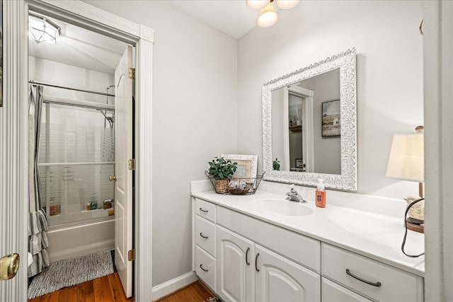 full bath featuring baseboards, shower / washtub combination, wood finished floors, and vanity