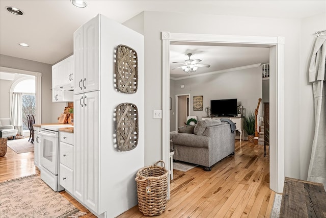 kitchen featuring ornamental molding, white range with electric stovetop, white cabinets, and light wood finished floors