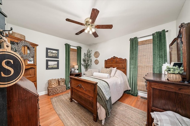 bedroom with ceiling fan, light wood finished floors, and baseboards