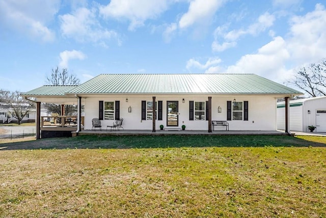 view of front facade featuring metal roof and a front yard