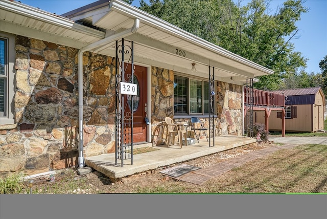 property entrance with covered porch and stone siding