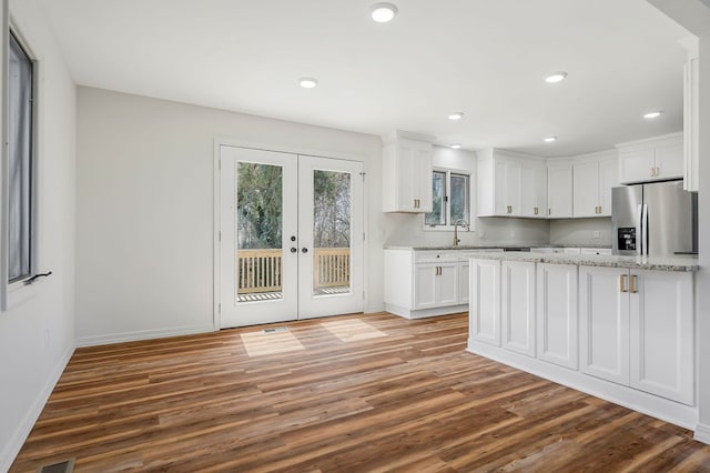 kitchen with white cabinets, french doors, and stainless steel refrigerator with ice dispenser