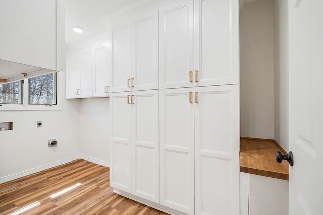 laundry area with baseboards, light wood finished floors, recessed lighting, cabinet space, and electric dryer hookup