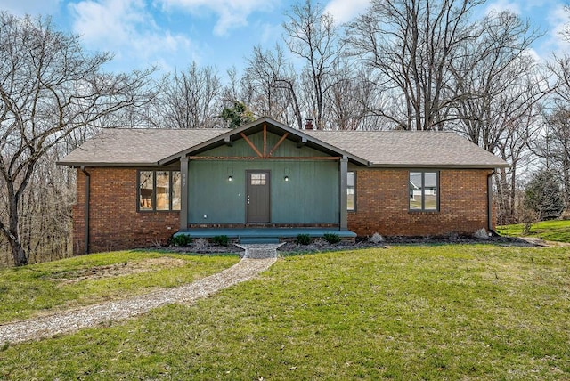 view of front of home featuring a front lawn, a porch, brick siding, and a shingled roof