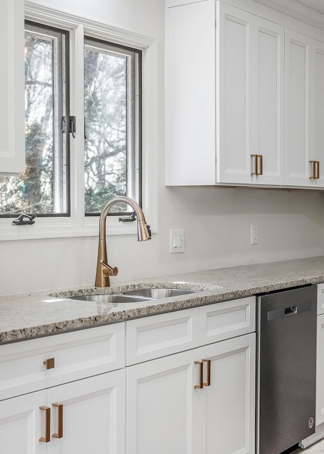 kitchen featuring a sink, stainless steel dishwasher, and white cabinets