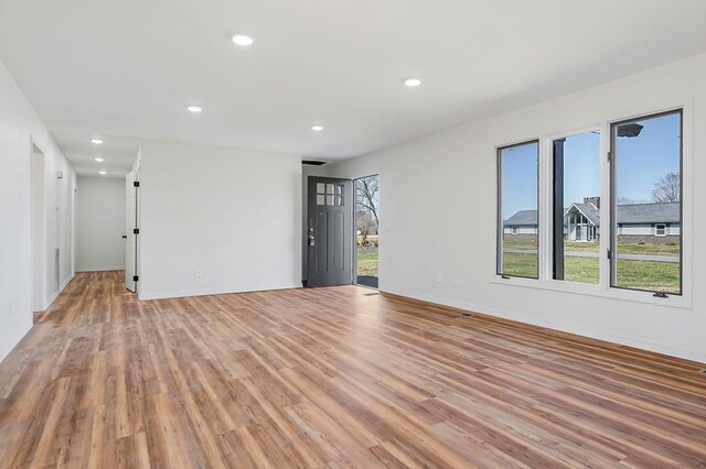 spare room with recessed lighting, baseboards, and light wood-style flooring