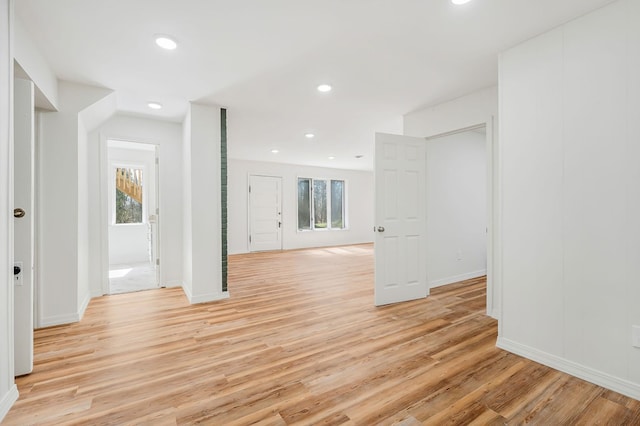 spare room featuring light wood finished floors, recessed lighting, and baseboards