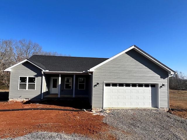 single story home featuring an attached garage, covered porch, crawl space, and gravel driveway