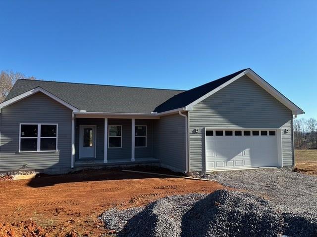 ranch-style home featuring a garage, driveway, and a porch