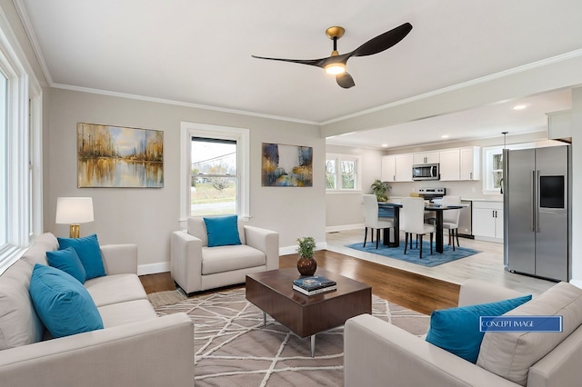 living room featuring baseboards, crown molding, light wood finished floors, and ceiling fan