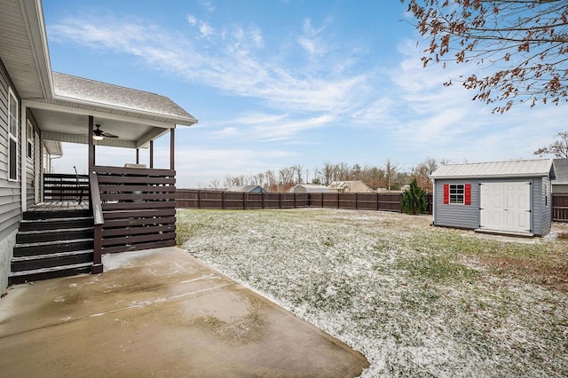 view of yard with a fenced backyard, a storage unit, ceiling fan, and an outdoor structure