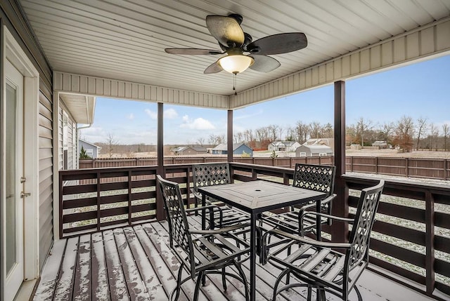 deck featuring a residential view, outdoor dining area, a fenced backyard, and ceiling fan