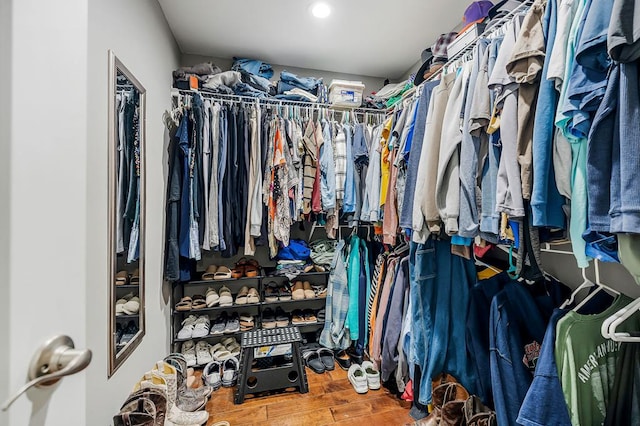 walk in closet with wood finished floors