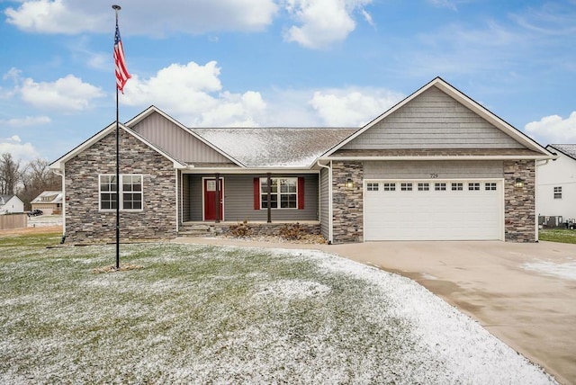 view of front facade featuring an attached garage, central air condition unit, driveway, stone siding, and a front lawn