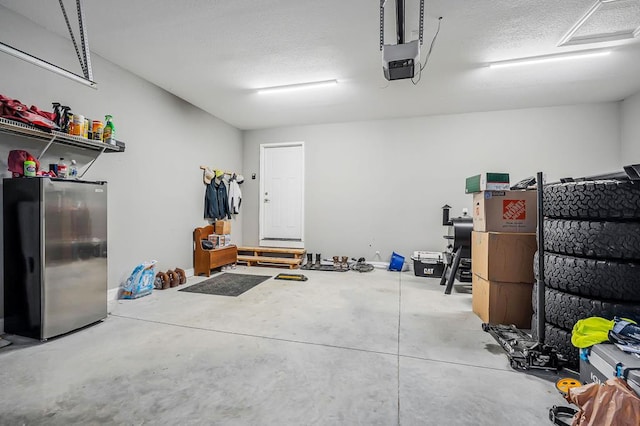 garage featuring a garage door opener and freestanding refrigerator