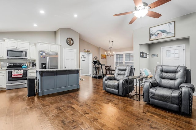 living area featuring lofted ceiling, dark wood-style floors, recessed lighting, and ceiling fan with notable chandelier