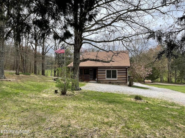 log-style house featuring log exterior and a front yard