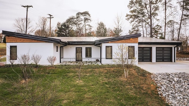 view of front of home with a garage, a front lawn, concrete driveway, and stucco siding