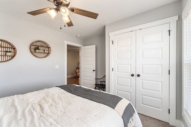 carpeted bedroom featuring ceiling fan and a closet