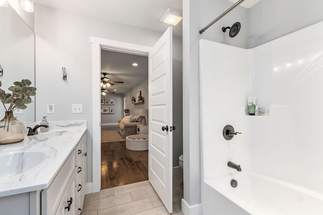 full bathroom with double vanity, ceiling fan, shower / washtub combination, and a sink