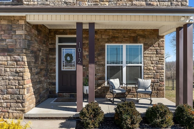 entrance to property featuring stone siding and covered porch