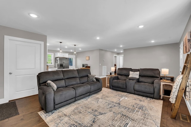 living room with visible vents, dark wood-type flooring, and recessed lighting