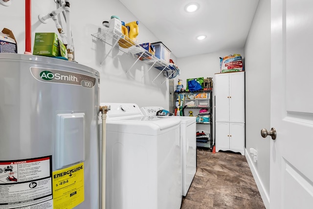 laundry area with laundry area, baseboards, electric water heater, stone finish flooring, and separate washer and dryer