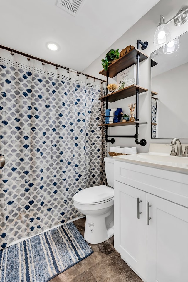 full bathroom featuring toilet, a shower with shower curtain, vanity, visible vents, and stone finish floor